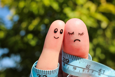 Finger art of couple with meter. The concept man is thin, woman is fat.の写真素材