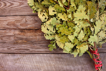 Oak broom for a bath on wooden background.の写真素材