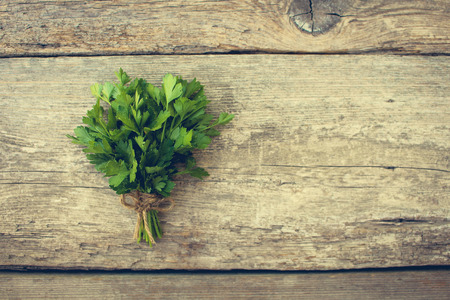Bunch fresh parsley on old wooden background. Toned image.の写真素材