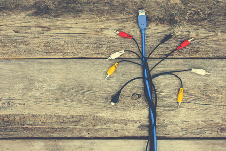 Connection plugs and wires on old wooden background. Toned image.の写真素材