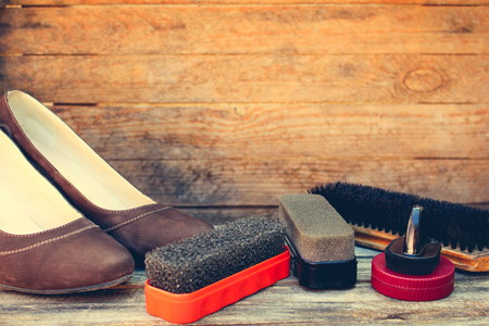 Women's shoes and care products for footwear on wooden background. Toned imageの写真素材