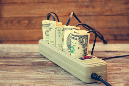 Socket and money. Concept of energy savings. Toned image.の写真素材