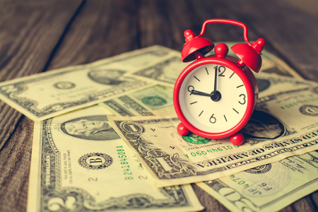 Clock on background of dollars. Concept of money is time. Toned image.の写真素材