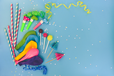 Candy, whistles, streamers, balloons on holiday table. Concept of children's birthday party. View top. Toned image.の写真素材
