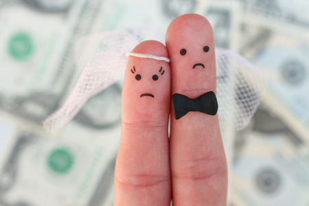 Fingers art of couple on background of money. Concept of wedding, woman and man needs to get married, but they do not want. Arranged marriage.の写真素材