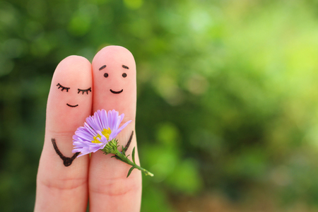 Fingers art of happy couple. Man is giving flowers to woman.の写真素材