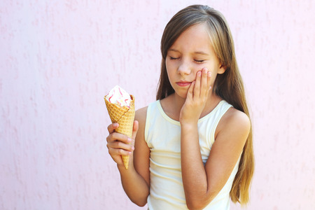 Girl has a toothache from cold ice cream.の写真素材