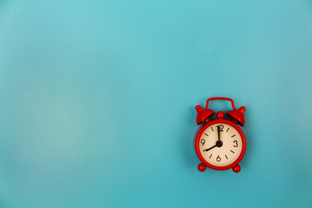Red alarm clock on blue background. Top view. Flat lay.の写真素材