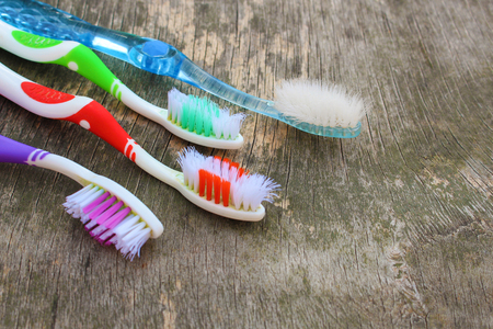 Close up of old toothbrushes on wooden background.の写真素材