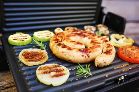 Grilled sausage and vegetables on old wooden background.  の写真素材
