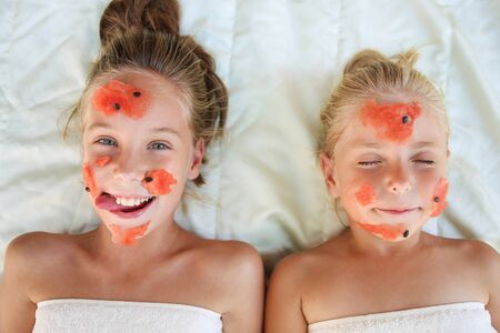 Beautiful girls with facial mask of watermelon. Top view.の写真素材