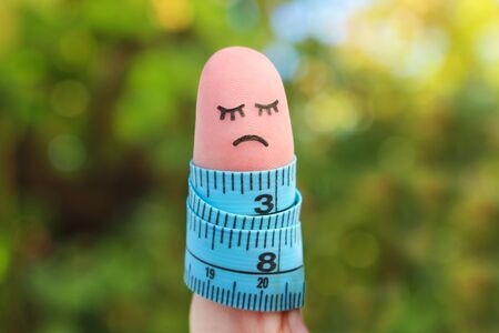 Finger art of lonely woman with meter. Concept she is fat.  の写真素材