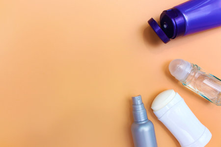 Different deodorants on beige background.