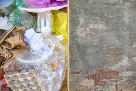 Box with trash on wooden background. Top view. Flat lay.