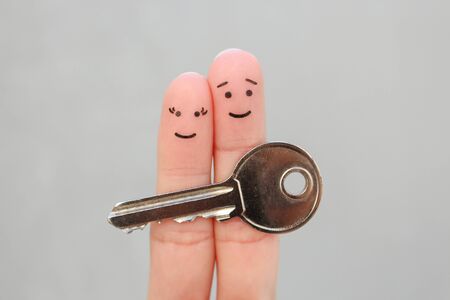 Fingers art of happy couple. Family holds house key.の写真素材
