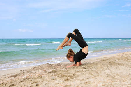 Girl doing sports exercises on the beach.の写真素材