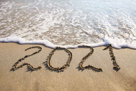 2021 year written on sandy beach sea. Top view. Flat lay.の写真素材
