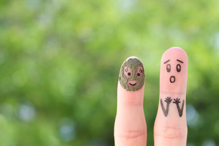 Fingers art of couple. Husband saw his wife with clay face mask and was afraid.