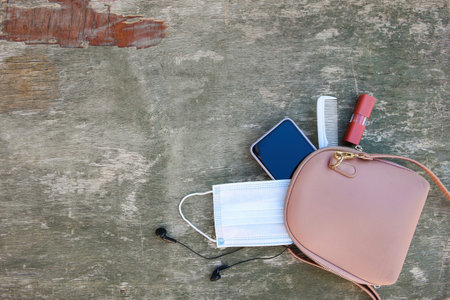 Things from open lady handbag. Concept of protect yourself from COVID-2019. Top view.