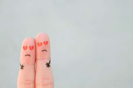 Fingers art of sad couple. Man and woman hug with broken hearts in eyes.