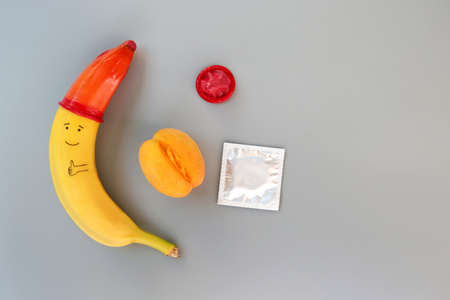 Banana with condom on a gray background.の写真素材
