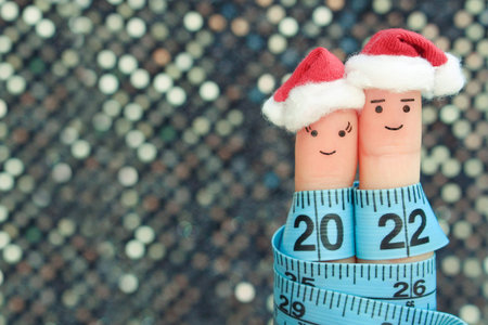Fingers art of couple celebrates Christmas. Concept of man and woman laughing in New Year hats....