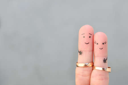 Fingers art of happy couple. Concept of a husband and wife wearing wedding rings.の写真素材