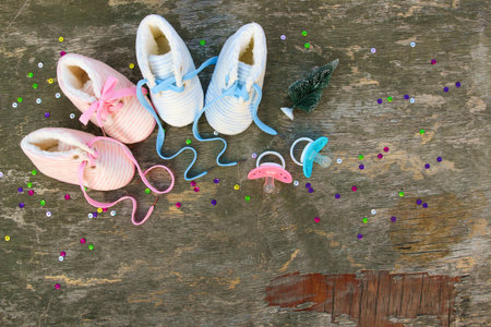 2022 new year written laces of children's shoes and pacifier on old wooden background. Top view....