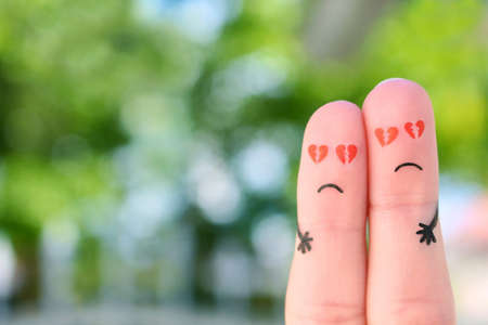 Fingers art of sad couple. Man and woman hug with broken hearts in eyes.の写真素材