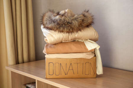 Donation box with winter clothes on the table.の写真素材