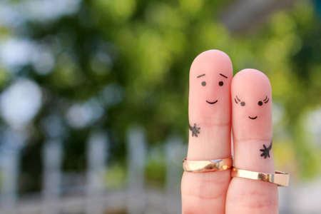 Finger art of happy couple. Concept of a husband and wife wearing wedding rings.の写真素材