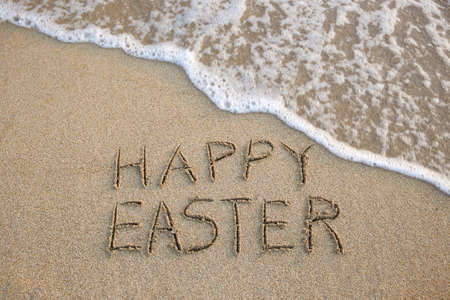 Happy easter written on sandy beach sea. top view.の写真素材