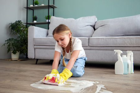 The child washes the floors of the house. The concept of child labor. The assistant.の写真素材