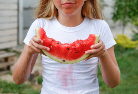 The child stained his clothes with watermelon.の写真素材