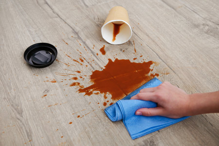 Paper cup of coffee fell on laminate, coffee spilled on floor.の写真素材
