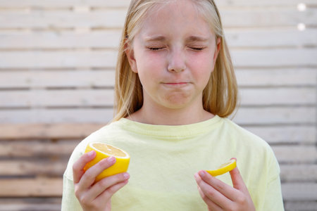 The child eats a sour lemon.の写真素材