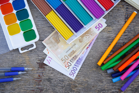 Office, school supplies and money on old wooden background. Concept is to buy stationary objects.の写真素材