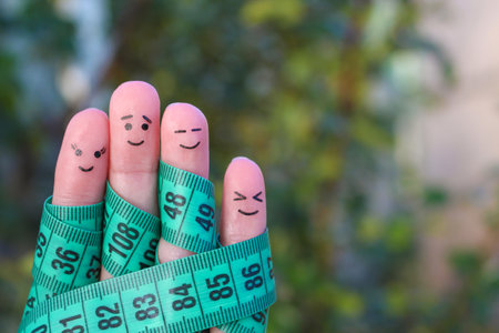 Fingers art of a Happy family with tape measure. Concept of losing weight togetherの写真素材