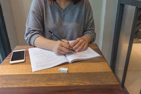 Young girl writing notes, take note, doing homeworkの写真素材