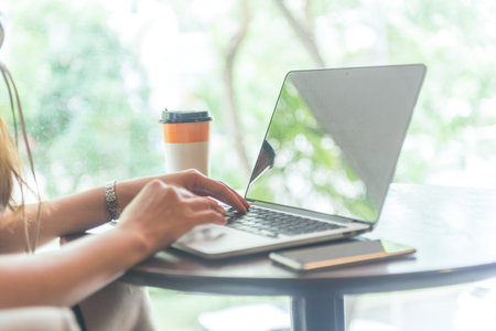 Side view of female hands using laptop