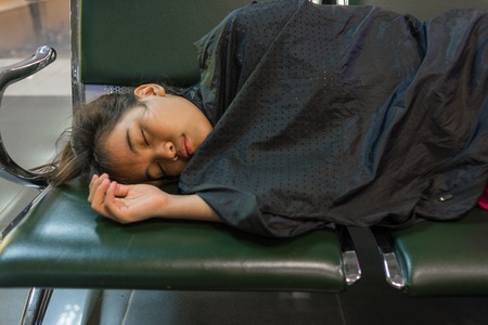 Young woman sleeping in the airportの写真素材