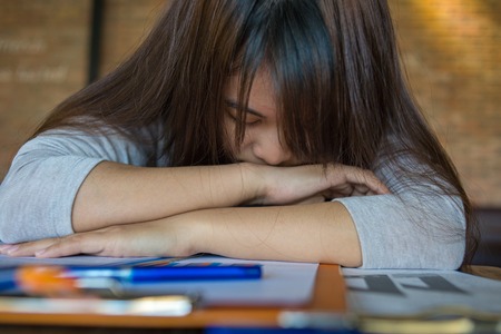 Young Asian employee feels tired, frustrated at workの写真素材