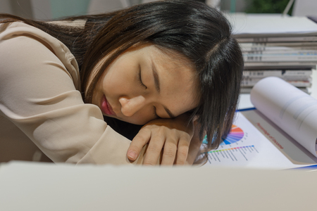 Young businesswoman sleeping at officeの写真素材