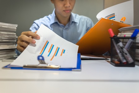 Businessman reading annual sales report in officeの写真素材