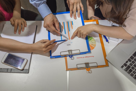 Business people point at the chart at the same time