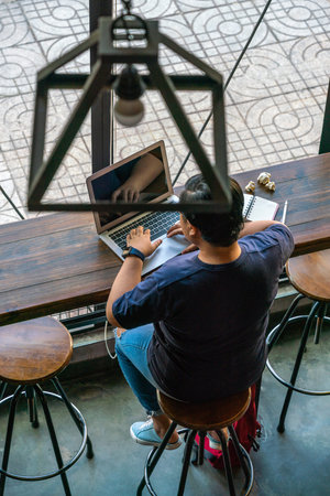 Asian Short-hair freelancer working hard on laptop in the coffee shop