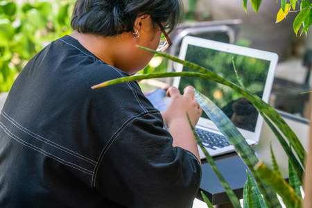 Asian teenager playing mobile game on smartphoneの写真素材