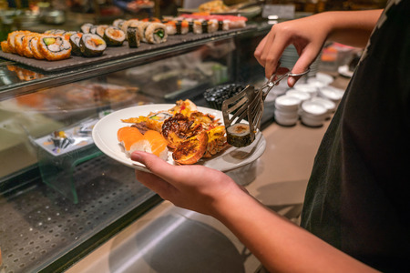 Man hand choosing sushi, lobster in the luxury buffetの写真素材