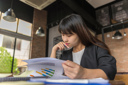 Young Asian businesswoman reading the sales reportの写真素材