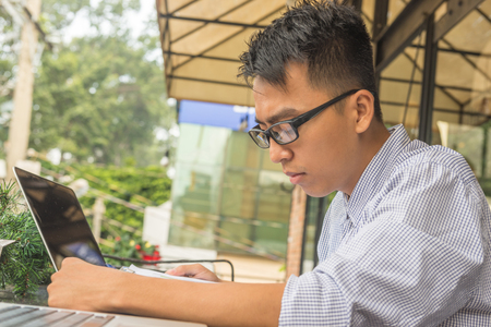 Young man reading financial report outdoor the officeの写真素材